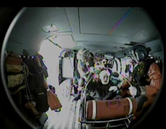 In this screen capture, Coast Guard Air Station Sitka crew aboard a MH-60 Jayhawk hoist a man experiencing chest pain from a fishing vessel in Southeast Alaska. (Screen capture courtesy U.S. Coast Guard)