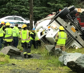 Authorities look over a cement truck that rolled over near the intersection of Mendenhall Loop and Back Loop roads on the morning of July 11, 2017.
