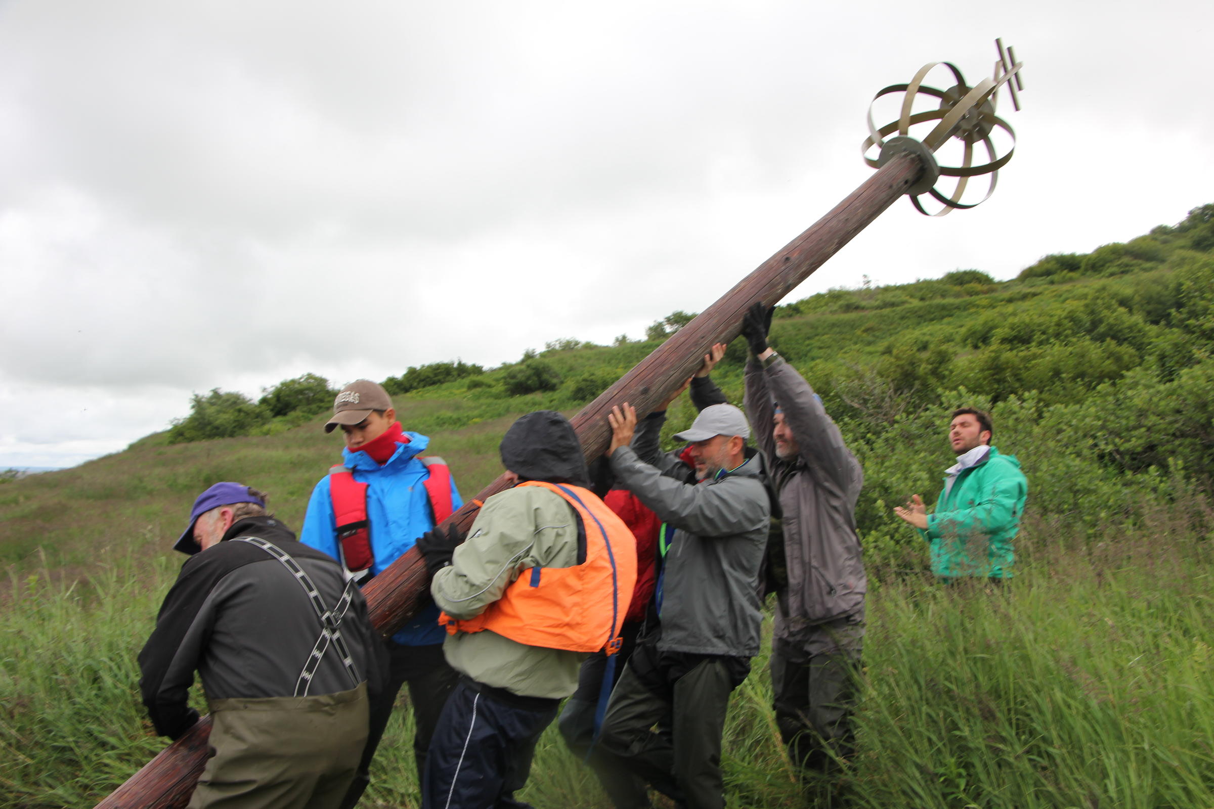 Members of the Russian expedition and Dillingham locals work to erect the monument at Nushagak. (Photo by Allison Mollenkam/KDLG)