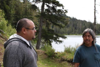 Albert Kookesh III (right) and Paul Thomas on the edge of Auk'Tah Lake. (Photo by Elizabeth Jenkins/Alaska's Energy Desk)