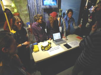 Ann Hill (left, at end of table) is wearing a yellow backpack-mounted radio antenna that was used in taking measurements of glaciers. Hill was part of the Juneau Icefield Research Program's geomatics team that surveyed ice elevation and flow during the summer of 2017, and she helped explain their research during a recent open house at the Mendenhall Glacier Visitor Center.