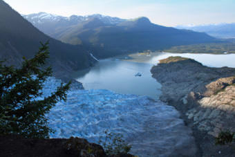 The morning sunlight approaches Mendenhall Glacier across Mendenhall Lake, as seen from Mount McGinnis on Aug. 14, 2012. Many hikers get lost and stranded trying to reach the glacier's ice caves below.