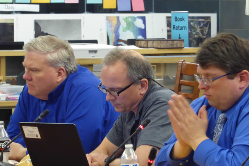 Sean O'Brien sits between Emil Mackey and Dan DeBartolo during a school board meeting in the Thunder Mountain High School Library.