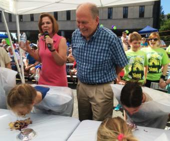 Alaska Gov. Bill Walker helps judge the Blueberry Arts Festival pie-eating contest in Ketchikan on Saturday. (Photo by Leila Kheiry/KRBD)