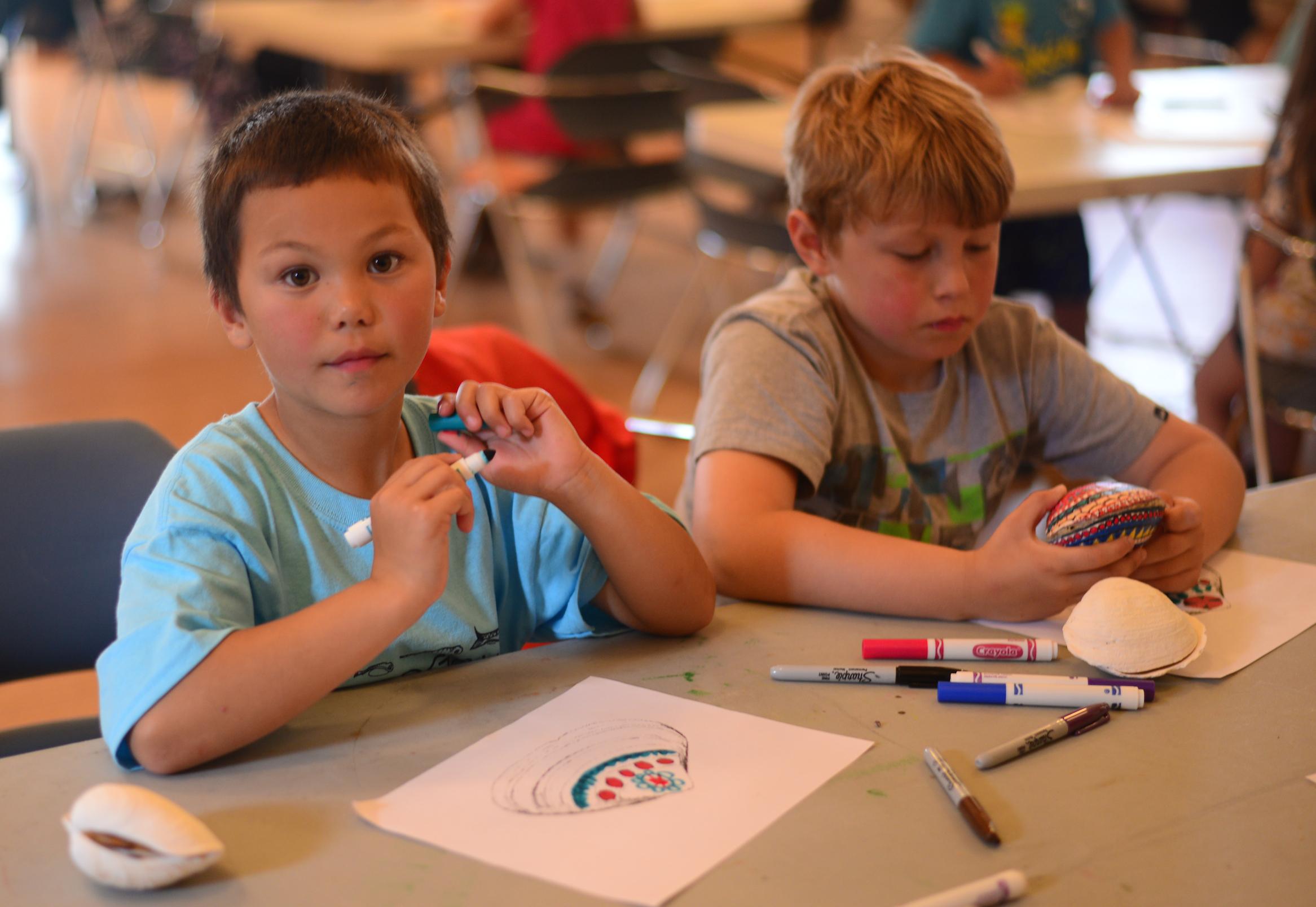 Campers draw draft clam rattle designs. (Photo by Berett Wilber/KUCB)