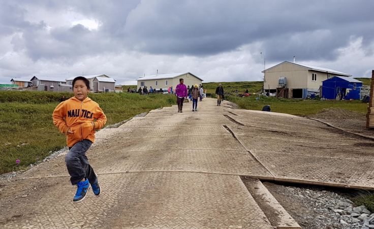 Excited Newtok children sprint down to Mertarvik's newly extended boat harbor. (Photo by Christine Trudeau/KYUK)