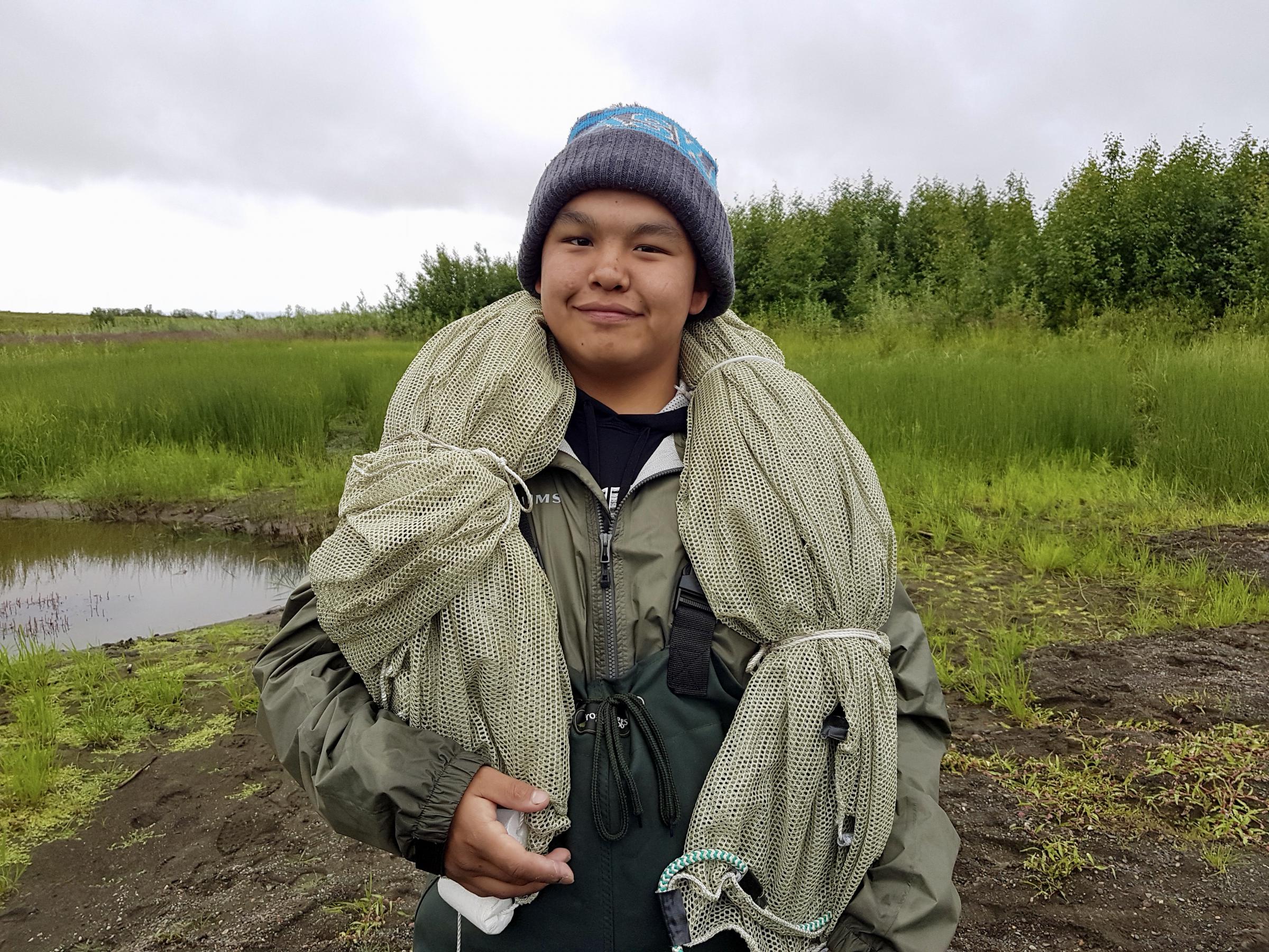 Orutsararmiut Native Council Summer Science and Culture camper Nicolai Chase, 16, gets ready to set up a beach seine net. (Photo by Christine Trudeau/KYUK)