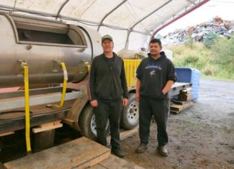 Brandon Thynes, Petersburg Indian Association’s Tribal Resource director, and his assistant Clifton Gudgel stand next to the tribe’s new composting machine, which is housed in a portable building at the Petersburg Borough’s baler facility. (Photo by Angela Denning/KFSK)