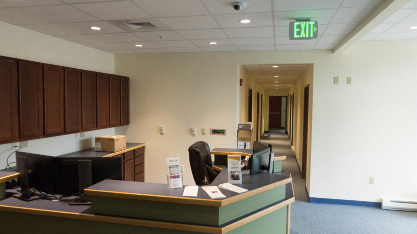 A reception desk with a hallway behind it with doors opening off it