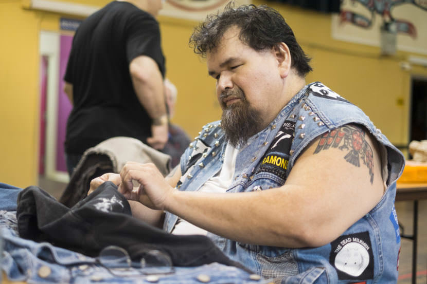 Alfie Price of Juneau sews patches and to a denim vest at Artists of All Nations on Sunday, Sep. 24, 2017. (Photo by Annie Bartholomew/KTOO)