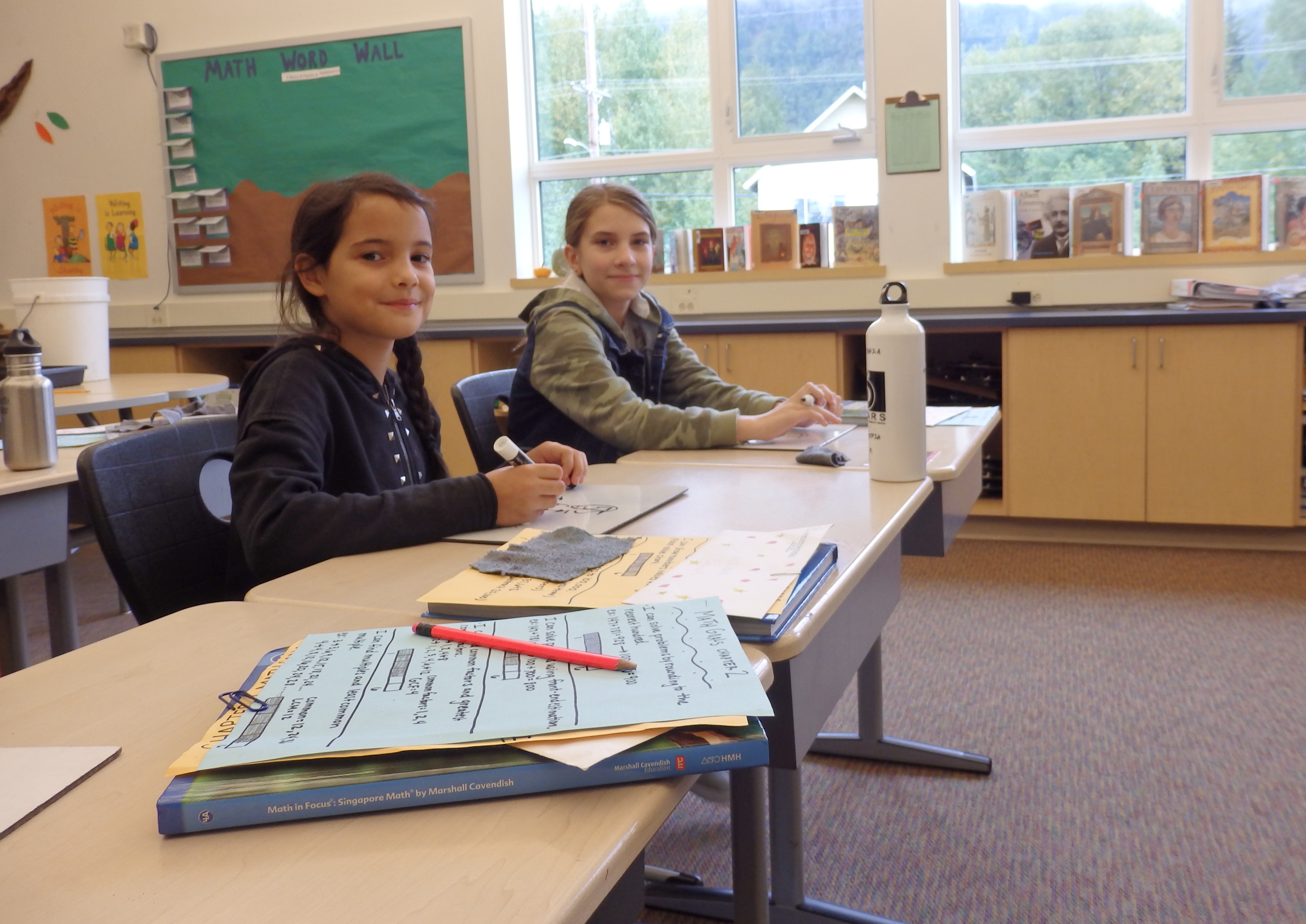 Costanza Marabini, left, went to school in Haines for about a month while visiting a family friend. Marabini sits next to fourth-grader Audrey Bader. (Photo by Emily Files/KHNS)