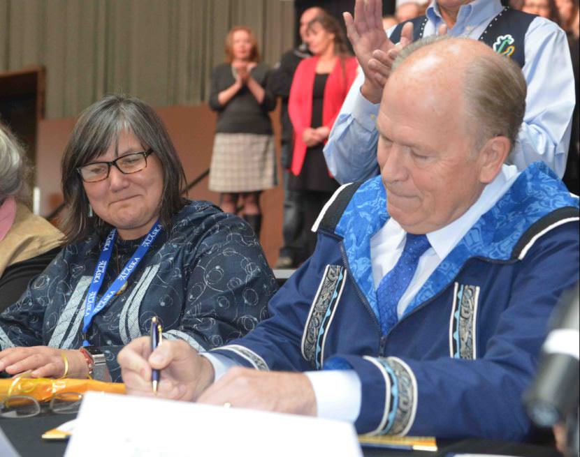 Gov. Bill Walker signs the Alaska Tribal Child Welfare Compact as Health and Social Services Commissioner Valerie Davidson watches at the 2017 Alaska Federation of Natives convention on Wednesday, Oct. 19, 2017.