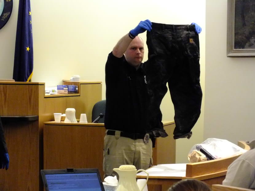 Detective Matt DuBois holds up a pair of Christopher Strawn’s pants that were found to be wet and muddy on the morning after the shooting of Brandon Cook. DuBois showed the pants to the jury during the homicide trial on Oct. 13, 2017.