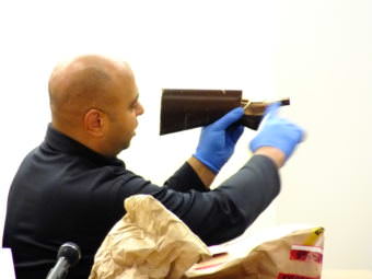 Sgt..Dominic Branson pieces together two pieces of a long gun butt stock that were found in Christopher Strawn’s trailer during his homicide trial on Oct. 13, 2017.