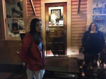 Ghost-tour guide Kelli Klees leads a group to some of Ketchikan’s haunted spaces. The Star Building on Creek Street, which houses Soho Coho, is home to a reported ghost. (Photo by Leila Kheiry/KRBD)