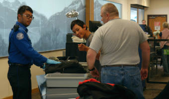 Transportation Security Officer Renier Cava preps passengers' carry-on belongings for X-ray screening at Juneau International Airport on Wednesday, Oct. 11, 2017.