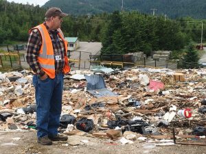 City of Ketchikan Solid Waste Superintendent Lenny Neely stands at the local landfill. He says discarded metal, construction material, bicycles and more are taken out of the dump through the city's salvage permit program. (Photo by Leila Kheiry, KRBD)