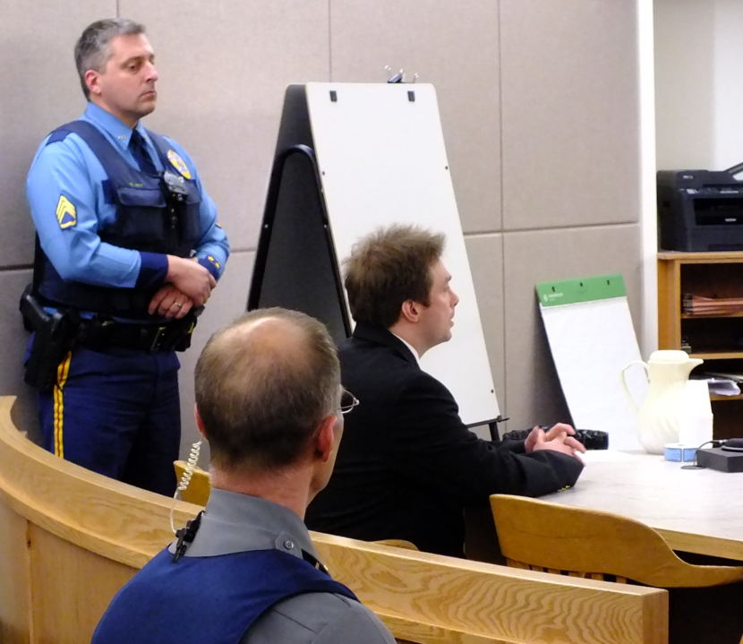 An Alaska State Trooper and a Judicial Services officer remain near Christopher Strawn as the verdict is read Oct. 18, 2017 in his homicide trial.