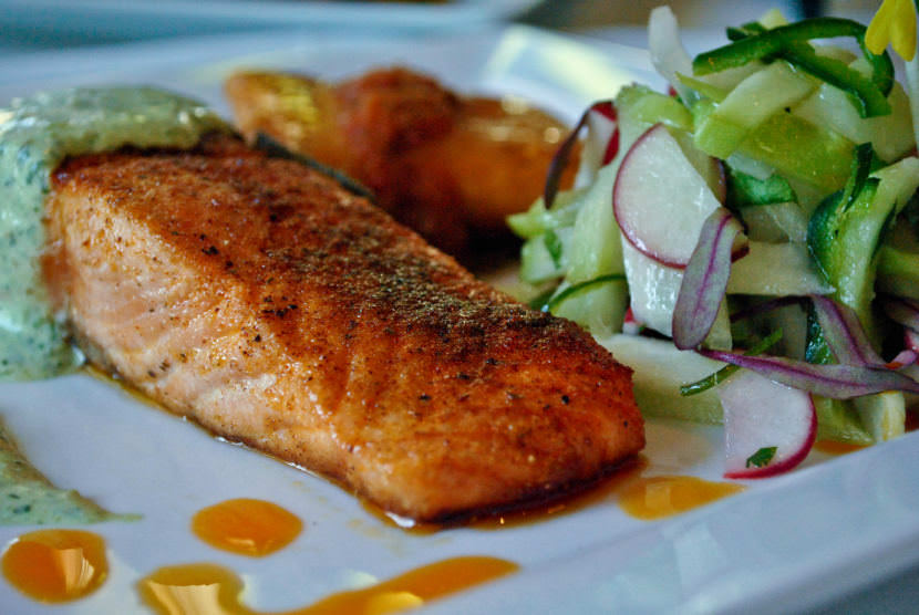 The Savory Street International Cafe in Sarasota, Florida, serves this ancho pepper crusted filet of salmon with a cilantro crema and a tomatillo, chayote, radish salad.