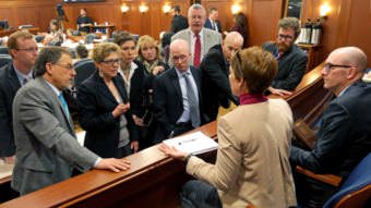 Legislators listen to Nancy Mead, General Counsel Alaska Court System, as she answers questions from the House gallery about the logistics of putting court records on line. The impromptu Q&A took place during an at-ease in discussions about amendments to SB 54 on November 5, 2017. If passed, SB 54 would amend Senate Bill 91, a major but controversial reworking of Alaska criminal justice laws passed last year. House speaker Bryce Edgemon, D-Dillingham, expects the amendment process to take several days. The legislators are (left to right): Reps. David Eastman, R-Wasilla, George Rauscher, R- Sutton, Gabrielle LeDoux, R-Anchorage, Ivy Spohnholz, D-Anchorage, Colleen Sullivan-Leonard, R-Wasilla, Jonathan Kreiss-Tomkins, D-Sitka, Dan Saddler, R-Eagle River, Dan Oritz, I-Ketchikan, and Justin Parish, D-Juneau. Also shown, at right, is Quinlan Steiner, Director of the Alaska Public Defender Agency. (Photo by Skip Gray/360 North)
