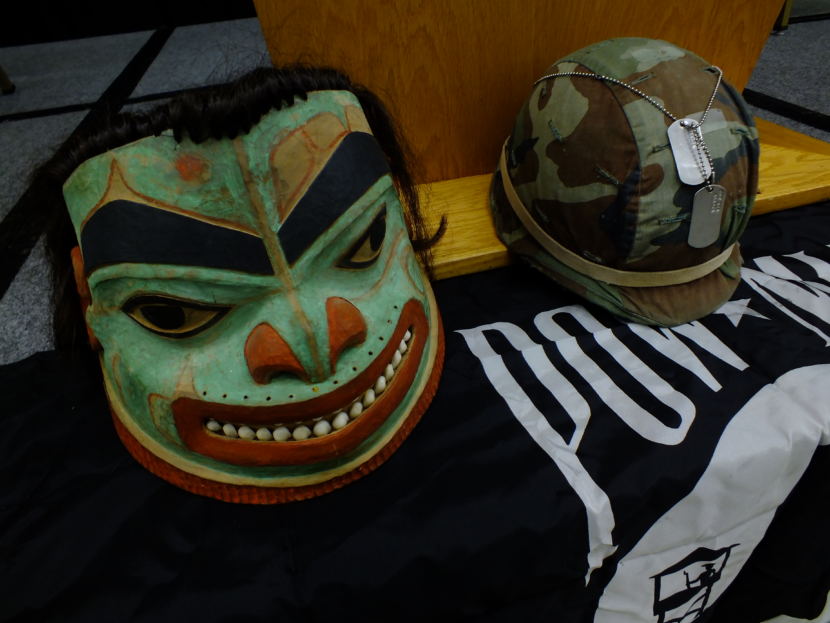 A Tlingit and modern day battle helmet are put on display during a Veterans Day observance at the Elizabeth Peratrovich Hall on Nov. 11, 2017. (Photo by Matt Miller/KTOO)