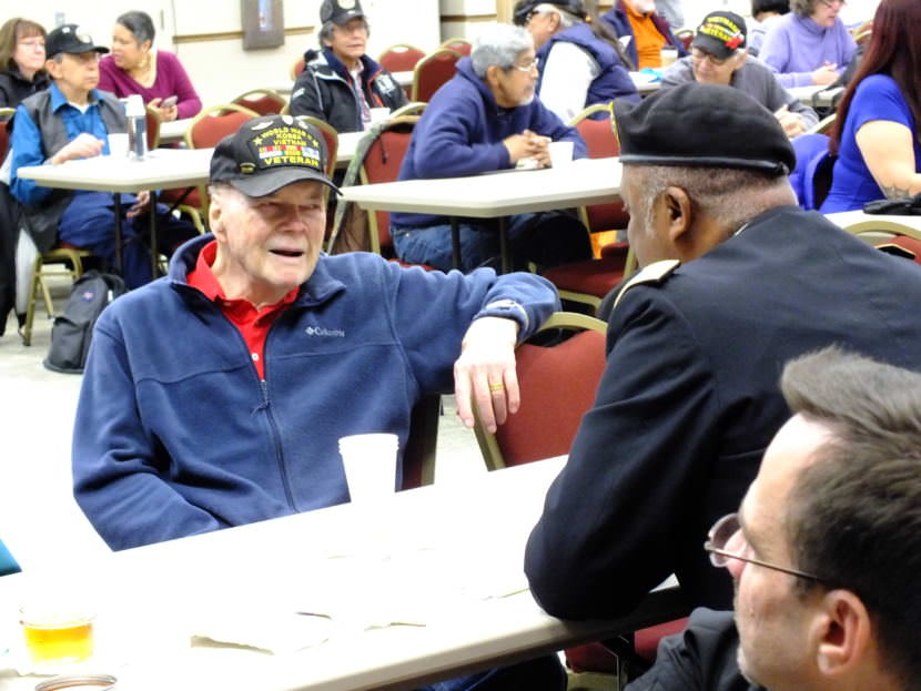 Retired Lt. Colonel Pat Carothers, a veteran of World War II, Korean and Vietnam wars, chats with a service member before a Veterans Day observance at the Elizabeth Peratrovich Hall on Nov. 11, 2017. (Photo by Matt Miller/KTOO)