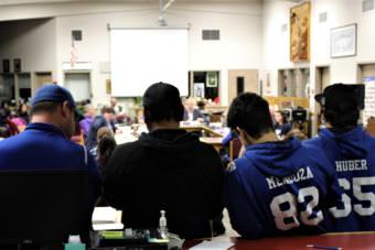 Thunder Mountain High School football players listen as other team members address the Board of Education over the plan to combine with Juneau-Douglas High School on Tuesday, Nov. 14, 2017. (Photo by Adelyn Baxter/KTOO)