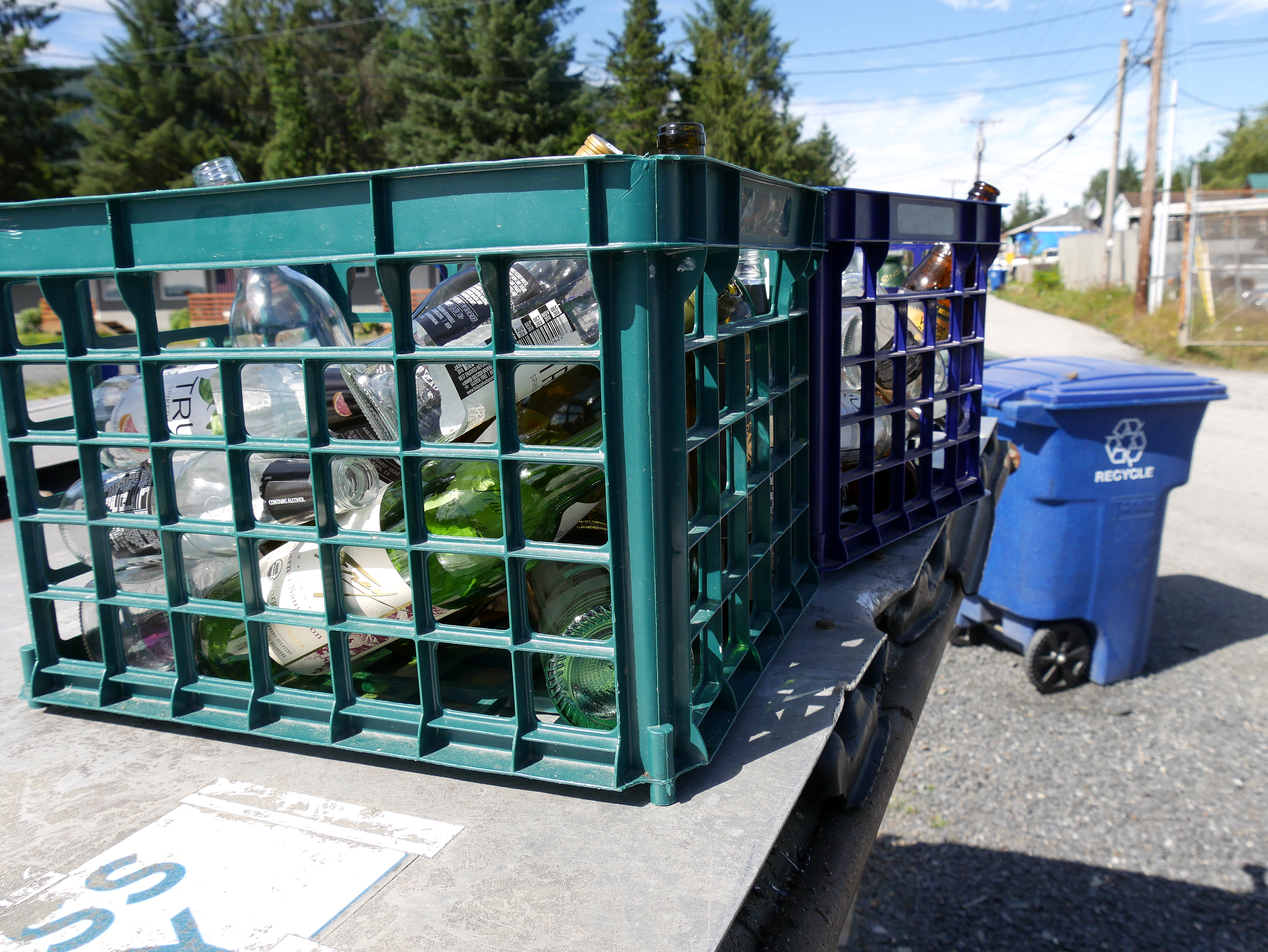 Crates of glass bottles sit on top of a “glass only” dumpster in Petersburg. (Photo by Angela Denning/KFSK)