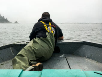 Jerome Nick Jr. perches in the front of the boat, checking to see if any Yurok tribal members are fishing. (Photo by Lisa Morehouse/KQED)