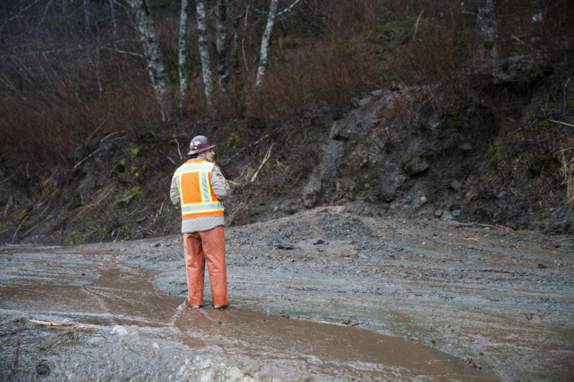 Isaiah Campos, maintenance foreman at the Alaska Department of Transportation, waits for road-clearing equipment to arrive after a mudslide on Monday, December 11, 2017, in Juneau, Alaska. The slide happened near the intersection of Mill Street and Thane Road south of downtown Juneau. (Photo by Rashah McChesney/Alaska’s Energy Desk)