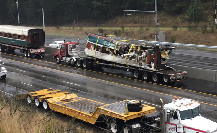 The rail cars that were dangling from a railroad overpass were loaded onto flatbed trucks. (Photo by Tom Banse/Northwest News Network)