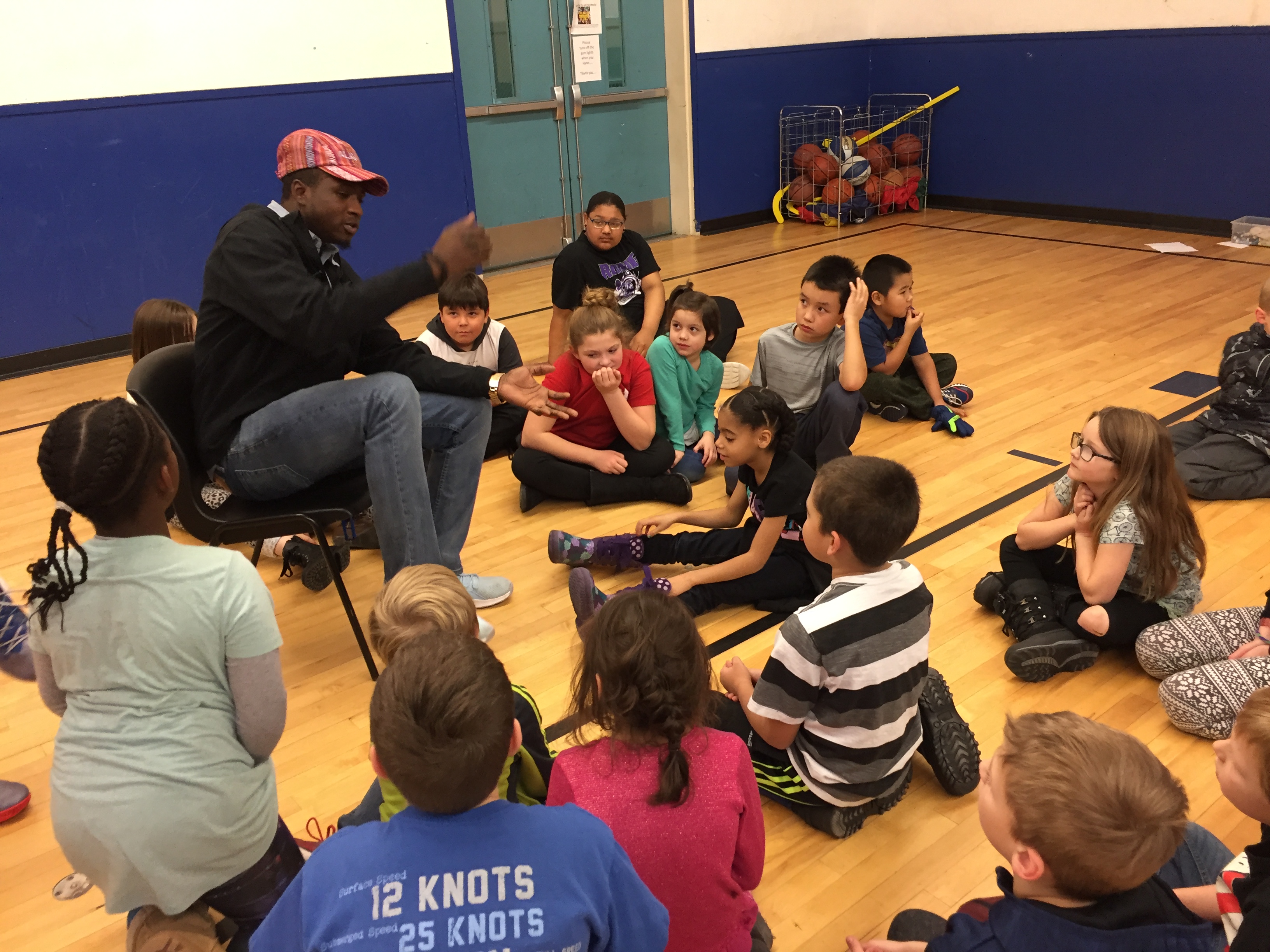 Kayrick Felton tells stories to children at the Woodland Park Boys & Girls Club in Anchorage while others prepare to present skits. (Photo by Anne Hillman/Alaska Public Media)