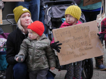 A woman and two children attend an anti-abortion rally outside the Alaska State Capitol on Monday, Jan. 22, 2018. The group Alaskans for Life organized the event.