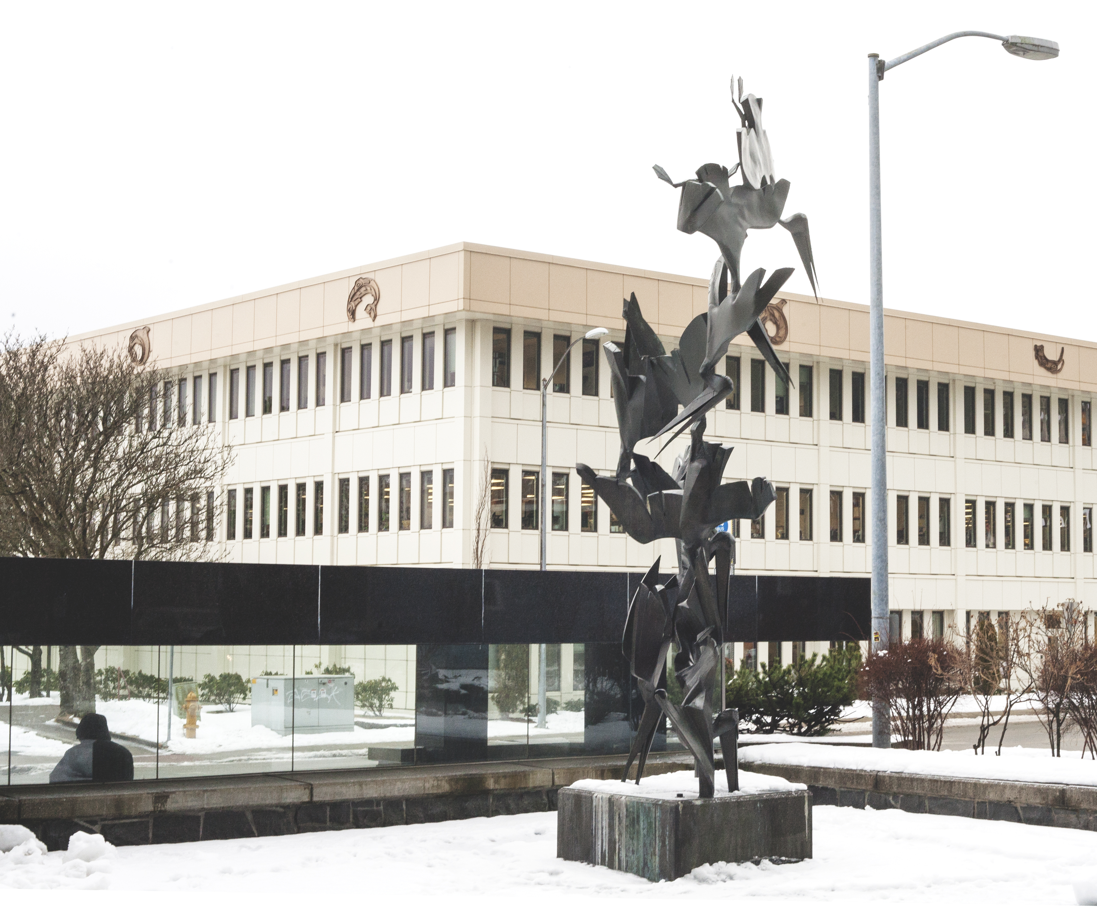 Bronze pelicans dive bomb the concrete behind a bus stop shelter near the Federal Building in Juneau on Thursday, Feb. 22, 2018. (Photo by Tripp J Crouse/KTOO)