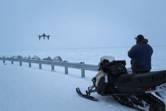 Dennis Davis flying his drone at the edge of Shishmaref a few days after a cold snap helped the sea ice freeze up late in January. (Photo by Zachariah Hughes/Alaska Public Media)