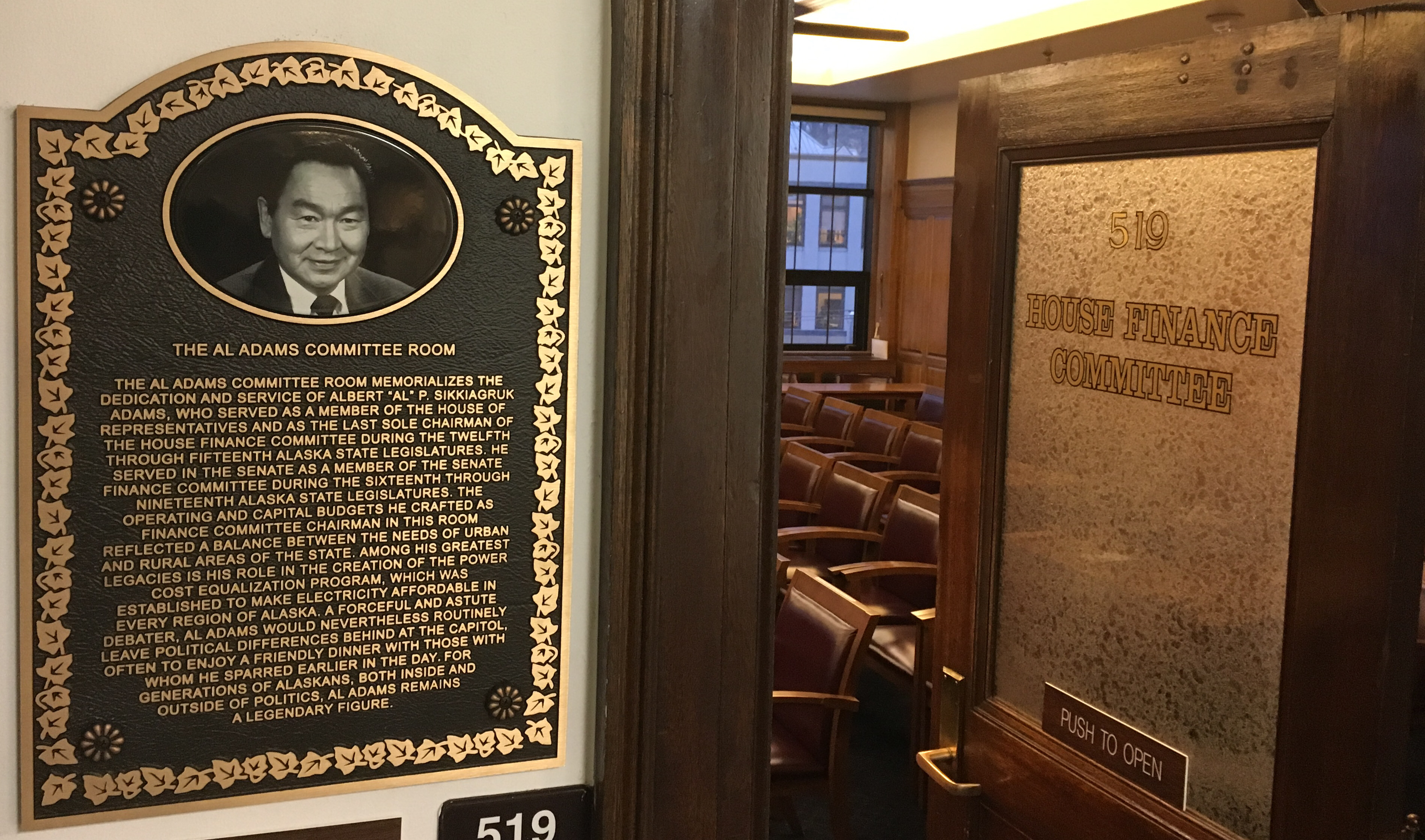 This plaque marks the newly renamed Al Adams Committee Room, where the House Finance Committee meets, Feb. 22, 2018. House finance subcommittees have been finishing their work this week. (Photo by Andrew Kitchenman/KTOO)