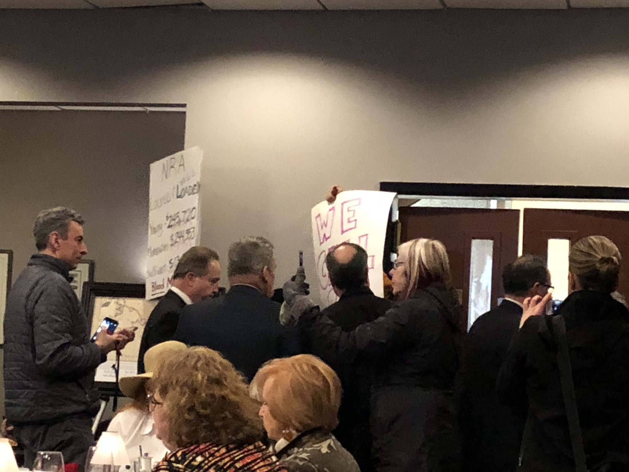 Protesters at an event featuring Sen. Lisa Murkowski and Rep. Don Young are quickly ushered out of the room on Monday, Feb. 19, 2018. (Photo by Elizabeth Harball/Alaska's Energy Desk)