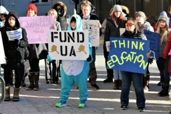 UA students and staff hold signs calling for more funding for higher education in Alaska at a rally on the state Capitol steps on Feb. 2, 2018. (Photo by Adelyn Baxter/KTOO).