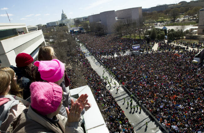 People on the balcony at the Newseum join with protesters on Pennsylvania Avenue as they look toward the stage near the Capitol during the rally. (Photo by Jose Luis Magana/AP)