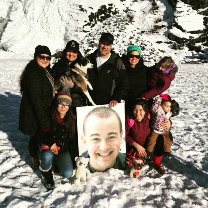 Family members pose with a portrait of Cody Eyre near the Mendenhall Glacier in Juneau in February 2018. Cody Eyre was killed by law enforcement in Fairbanks on Dec. 24, 2017, and his family is seeking more information about the incident.