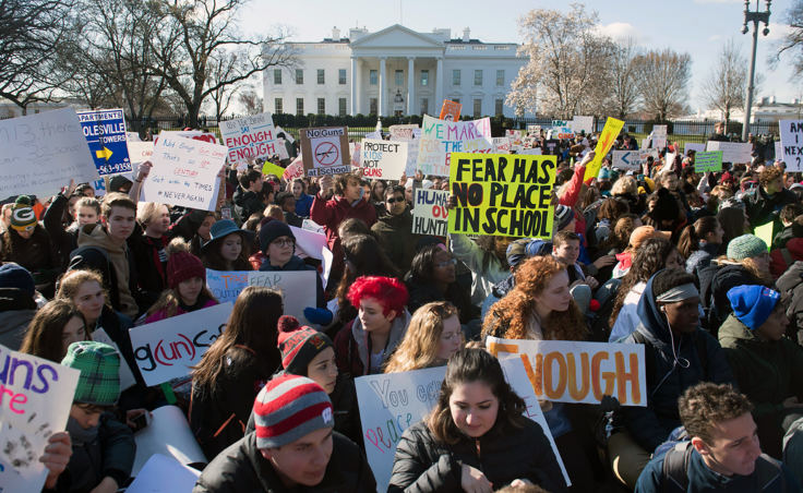 During a nationwide student walkout, thousands of local students sit in front of the White House in Washington, D.C., for 17 minutes in honor of the 17 students killed last month in a high school shooting in Florida.
