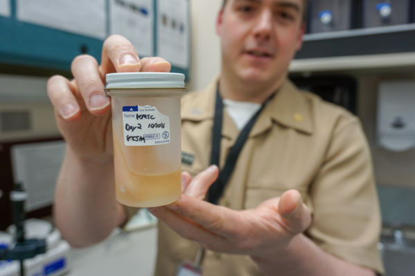 Chris Dankmeyer displays a sample of seal oil from a series of experiments working to get seal oil approved for state-licensed facilities. (Photo by Anne Hillman/Alaska Public Media)