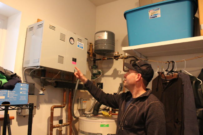 Philip Richards points to his electric boiler. (Photo by Elizabeth Jenkins/Alaska's Energy Desk)