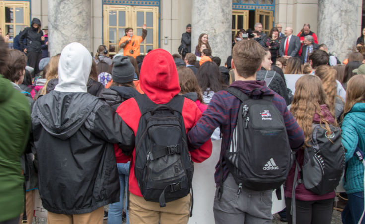 Students link arms in solidarity at a student walkout protest at the Alaska State Capitol building in Juneau on Wednesday, March 14, 2018.