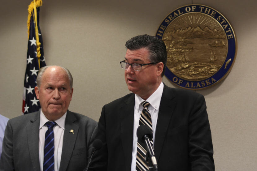 Alaska Gov. Bill Walker watches Alaska Gasline Development Corporation President Keith Meyer talk to reporters during a press conference on March 5, 2018, in Anchorage, Alaska. (Photo by Victoria Petersen/Alaska Public Media)