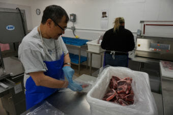 Cyrus Harris and Brittnay Anderson package meat at the Siglauq in Kotzebue. (Photo by Hillman/Alaska Public Media)