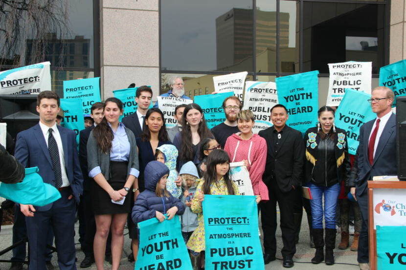 The young plaintiffs in Sinnok v State of Alaska gathered with their attorneys and supporters outside the Nesbett Courthouse in downtown Anchorage after oral arguments on Monday, April 30. The state is asking the court to dismiss their lawsuit. (Photo by Rachel Waldholz / Alaska's Energy Desk)