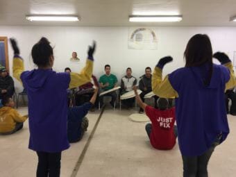 The Hooper Bay youth dancers practice in late winter. A memorial to one of their members adorns the wall. (Photo by Anne Hillman/Alaska Public Media)