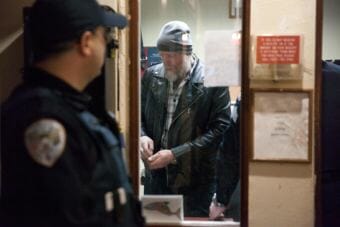 Juneau police officers confer as they arrest Chuck Cotten, property manager at the Bergmann Hotel. Cotten was responsible for removing residents from their rooms before Friday March 10, 2017 in Juneau, Alaska. The building has been condemned. (Photo by Rashah McChesney/Alaska's Energy Desk)