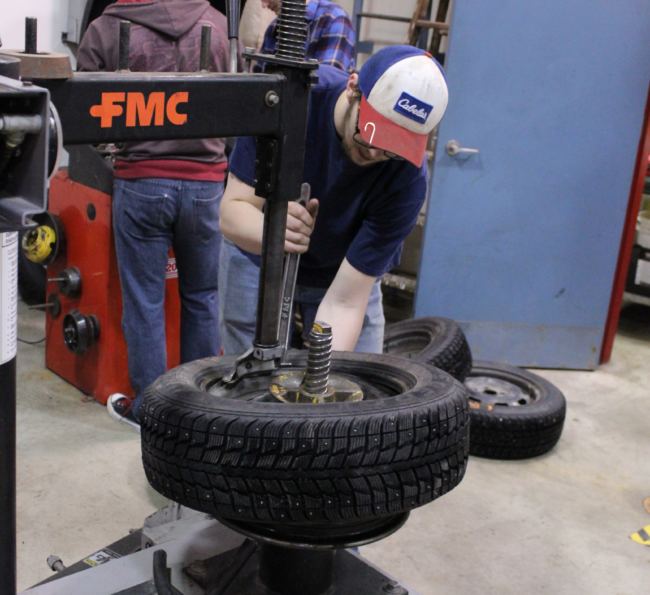 Senior Dylan Rice adjusts a tire during an automotive class in the UAS Technical Education Center. (Photo by Adelyn Baxter/KTOO)